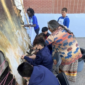 People huddled around a hide tanning station