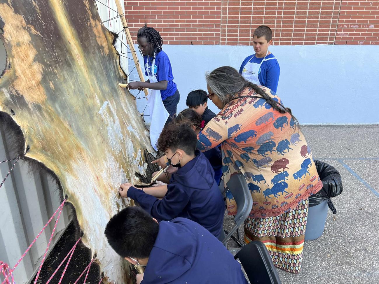 People huddled around a hide tanning station