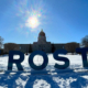 Giant letters spell out "FROST", with the Saskatchewan Legislative Building in the background.